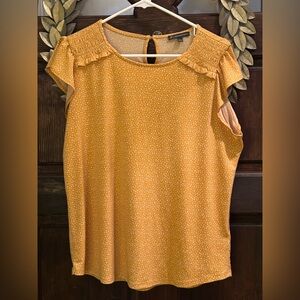 Mustard yellow short sleeved blouse with white small designs. Buttons in back